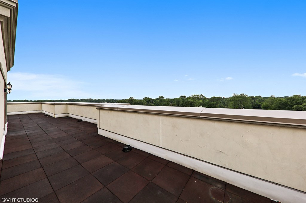 a balcony with a view of the water and a blue sky