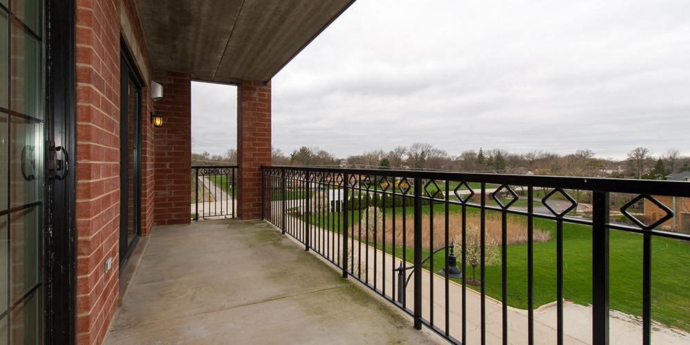 a balcony with a black fence and a brick building at Countryside 10765, Countryside