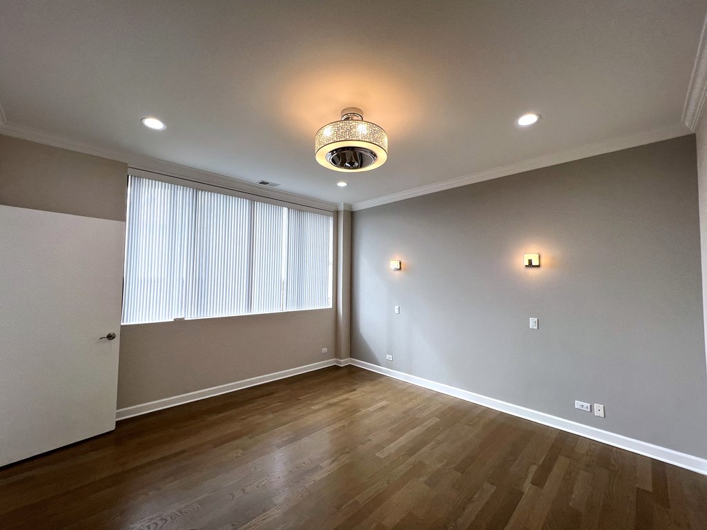 a living room with wood flooring and a large window