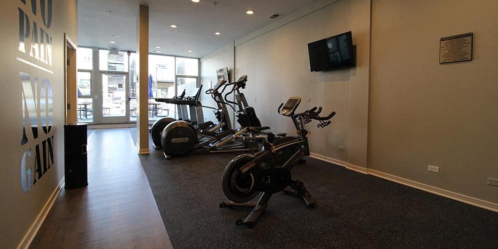 a workout room with exercise bikes and a tv  at Fullerton 1540, Chicago, Illinois