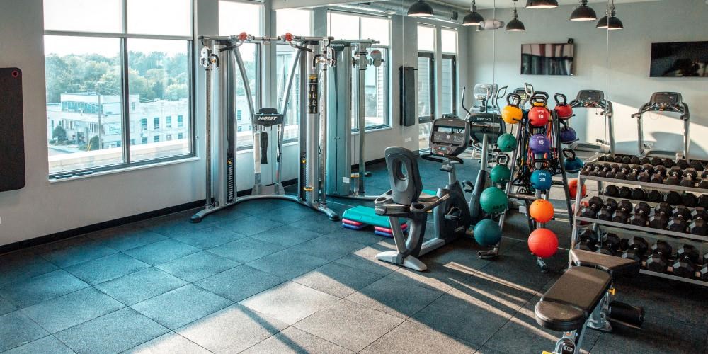 a gym with a lot of weights and a large window at Barrington 101, Chicago