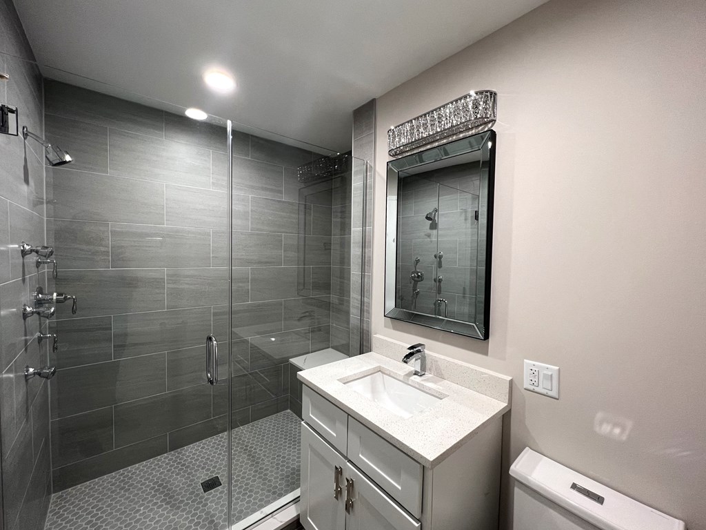 a bathroom with a shower and a sink and a mirror
