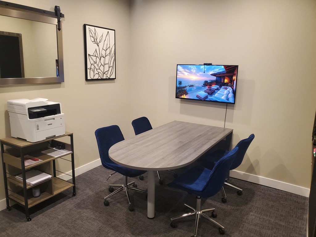 a conference room with a table and a tv