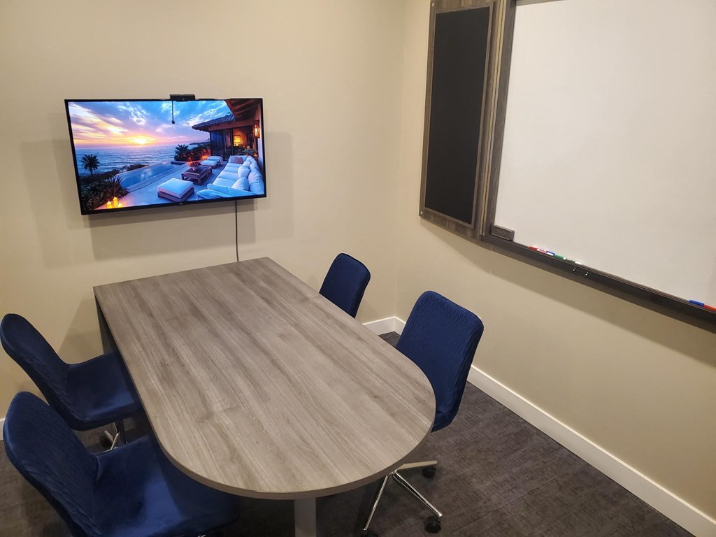 a conference room with a table and a tv on the wall