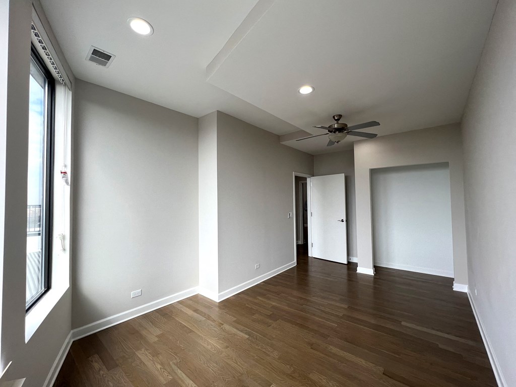 a living room with white walls and a ceiling fan