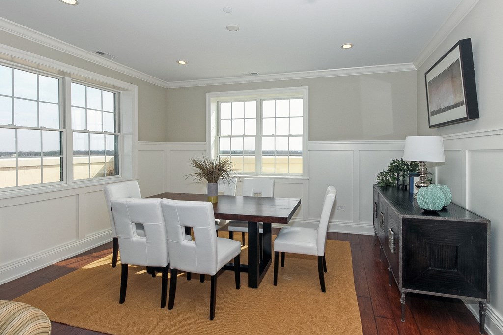a dining room with a wooden table and white chairs