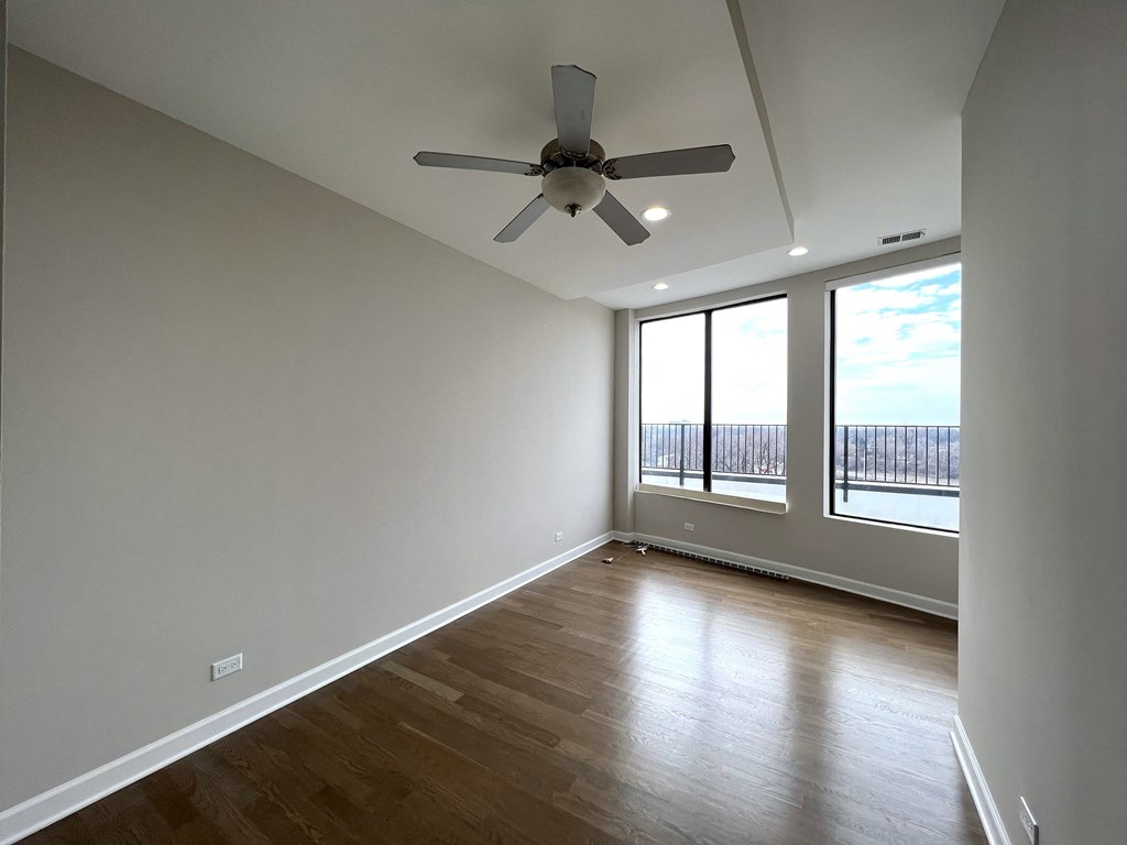 a living room with wood floors and a ceiling fan