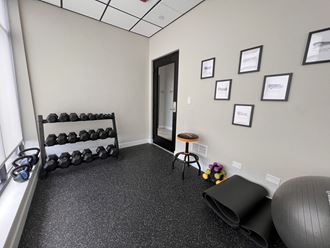 a fitness room with weights and a treadmill