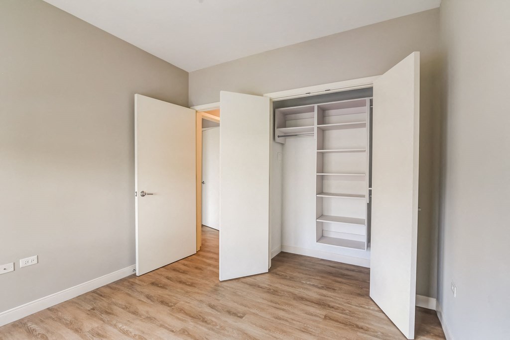 a bedroom with an open closet and a wood floor at Clarendon Hills 229, Illinois