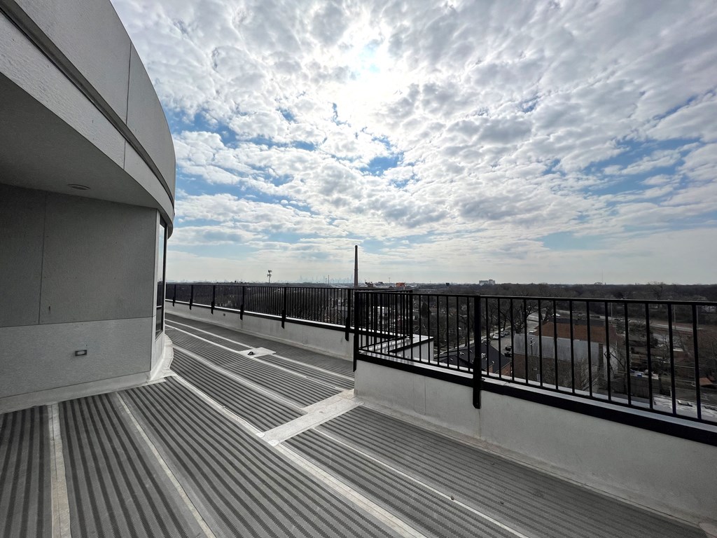 a balcony with a view of the city and the sky