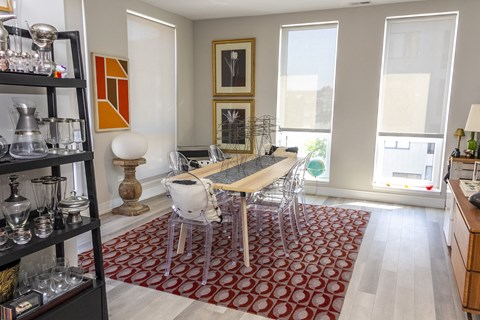 a dining room with a wooden table and chairs and a red rug