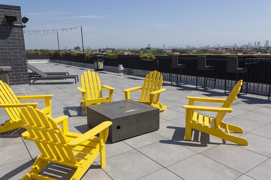 a group of yellow chairs around a fire pit on top of a roof at Talman 1554, Illinois