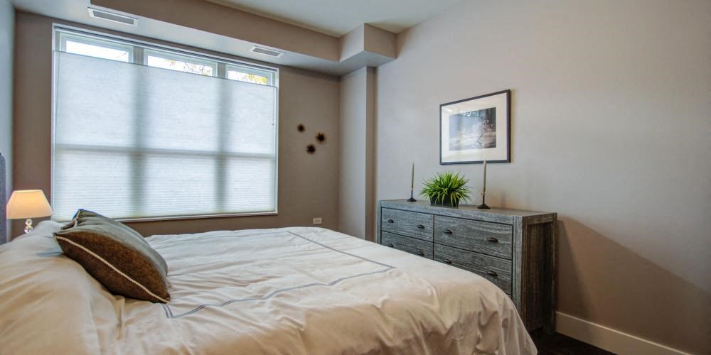 a bedroom with a bed and a dresser and a window at Barrington 101, Barrington Illinois