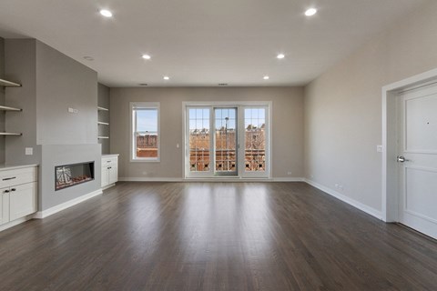 an empty living room with a fireplace and a window