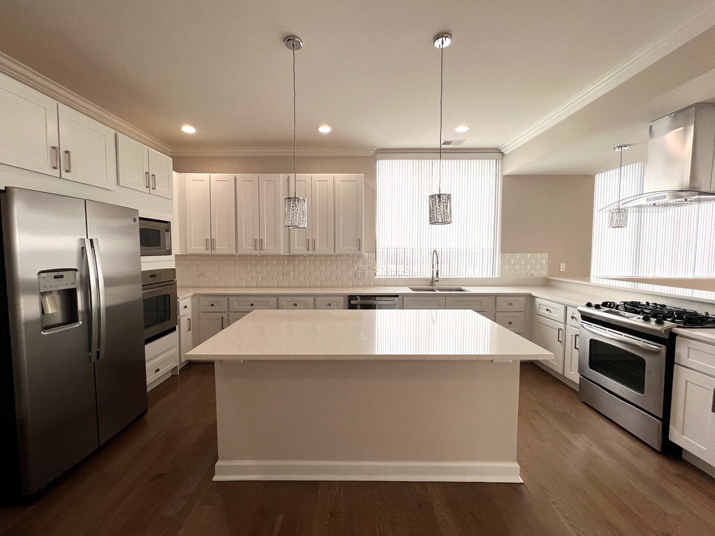 a large white kitchen with stainless steel appliances