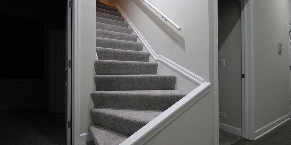 a gray carpeted staircase with a white railing and a door  at Elston 3434, Illinois, 60618