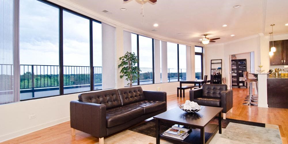 a living room with leather furniture and large windows