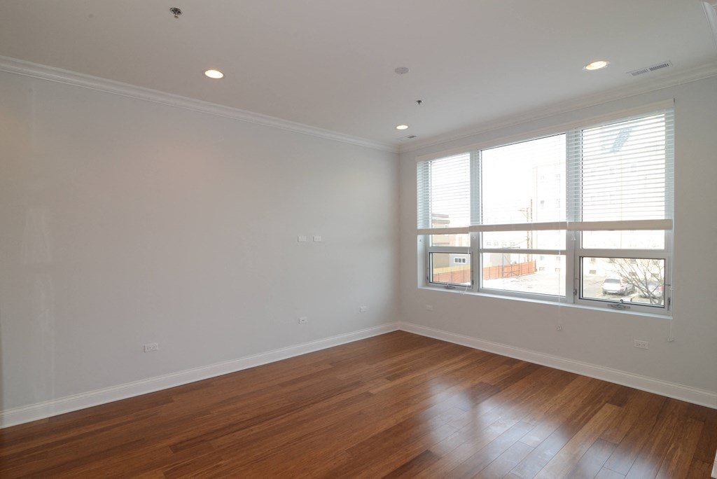 a living room with wood floors and a large window