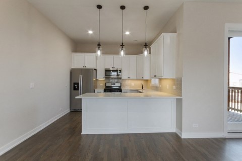 a kitchen with white cabinets and a counter top and a refrigerator