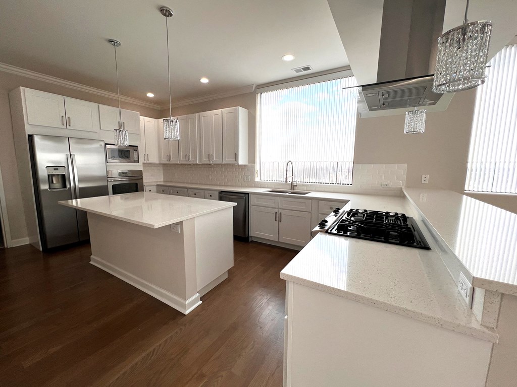 a kitchen with white counter tops and stainless steel appliances