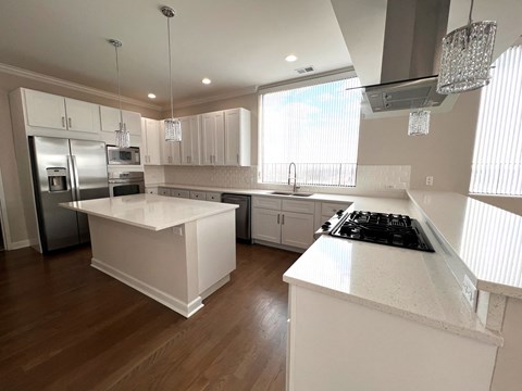 a kitchen with white counter tops and stainless steel appliances