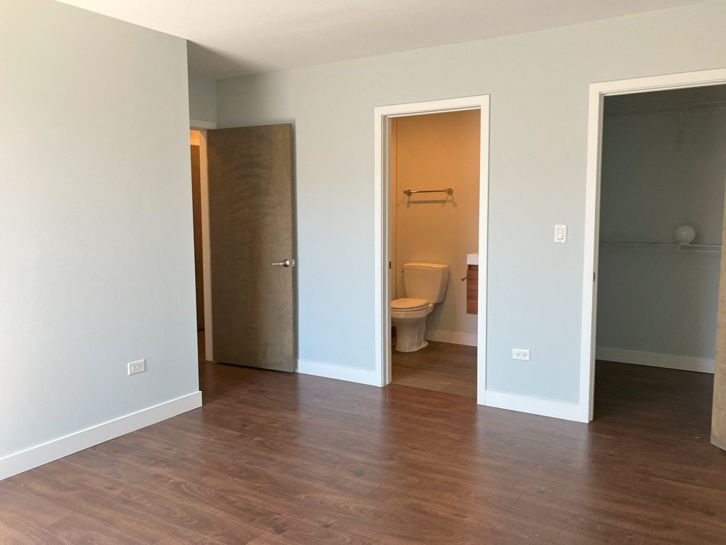 an empty room with a toilet and a door to a bathroom
