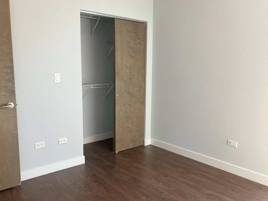 a bedroom with a closet and a hard wood floor