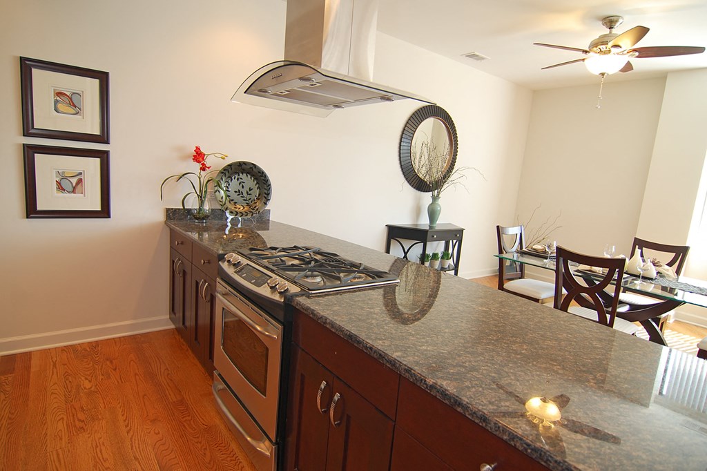 a kitchen with a granite counter top and a dining room with a table and chairs