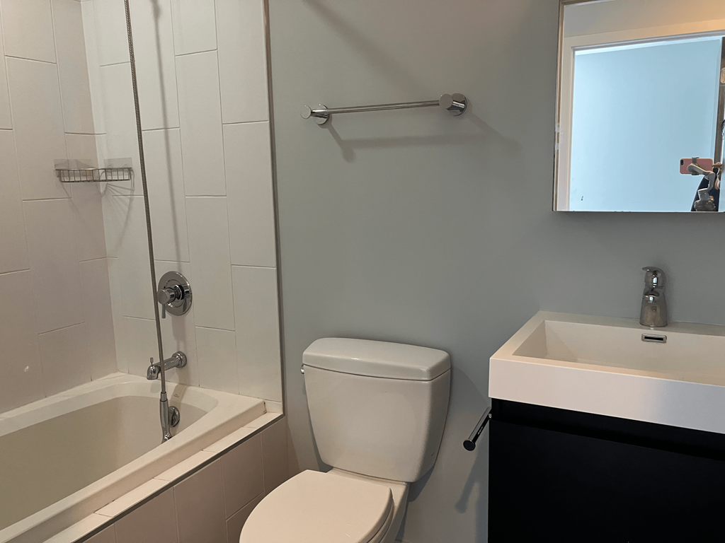 a bathroom with a toilet and a tub and a sink