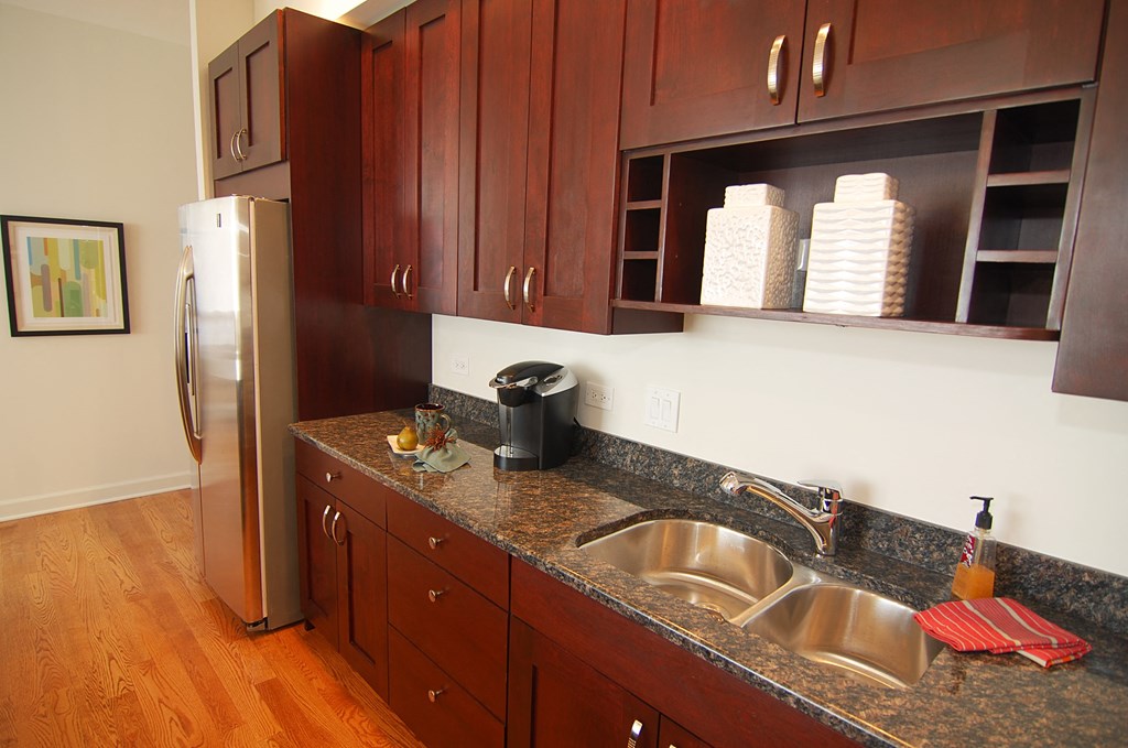 a kitchen with a granite counter top and a stainless steel refrigerator