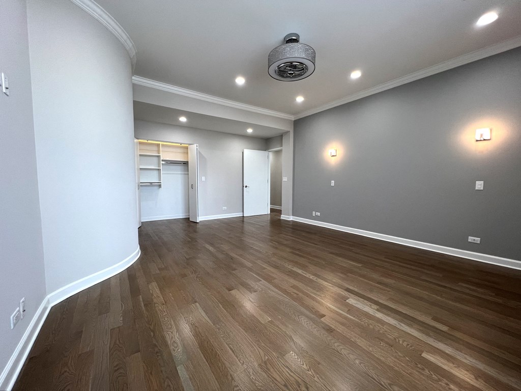 a living room with a hard wood floor and grey walls