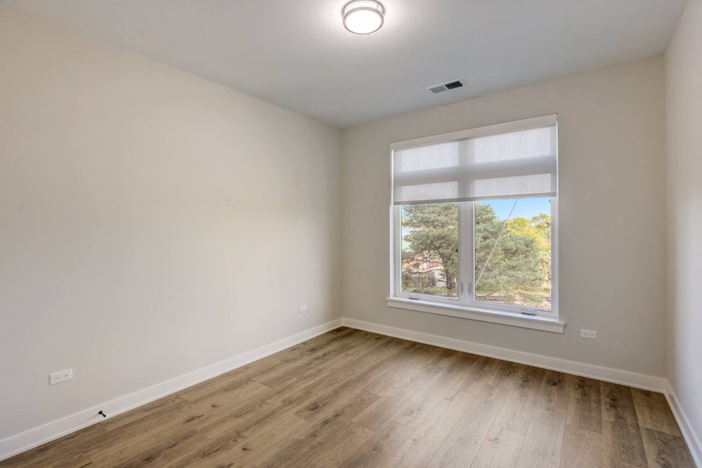 an empty room with wood floors and a window at Highwood 440, Highwood, IL