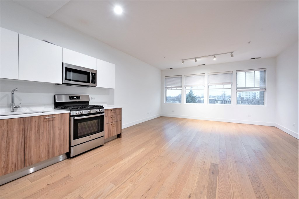 an empty kitchen and living room with wood flooring and white walls at Wilmette 1121, Wilmette, IL