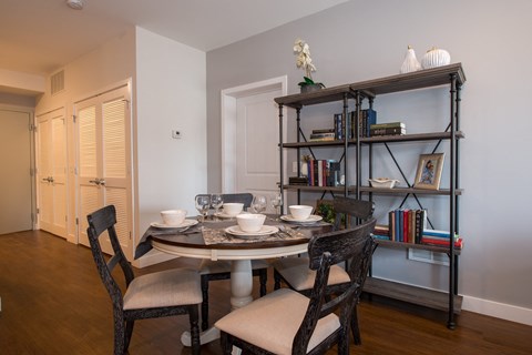 a dining room with a table and chairs and a bookshelf