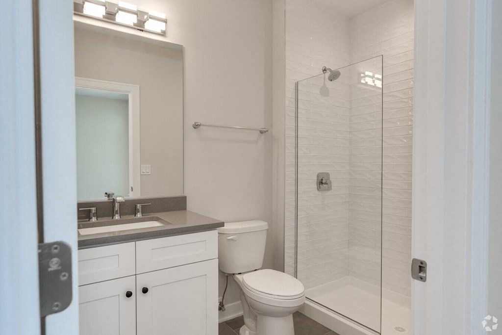 a white bathroom with a shower toilet and sink  at Highwood 246, Highwood