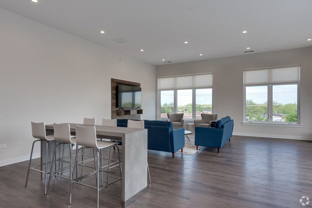 a living room with a table and chairs and a television  at Highwood 246, Highwood