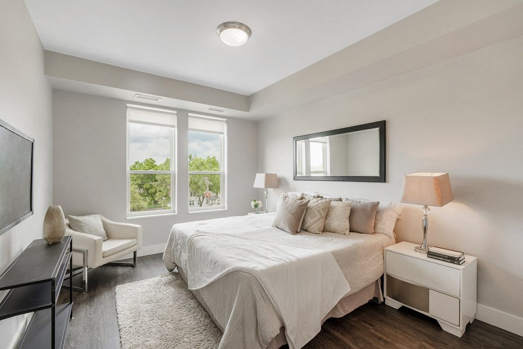 a white bedroom with a bed and a tv at Barrington 101, Illinois