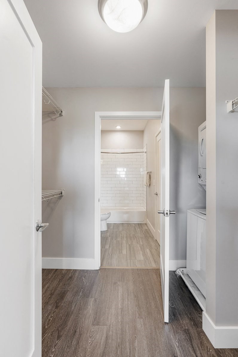 a white bathroom with a toilet and a walk in closet at Barrington 101, Chicago