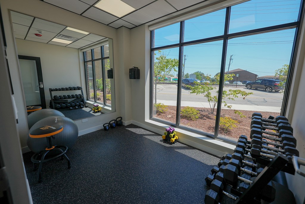 a fitness room with rows of chairs and large windows
