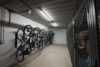A bike rack with many bikes in a dark room.