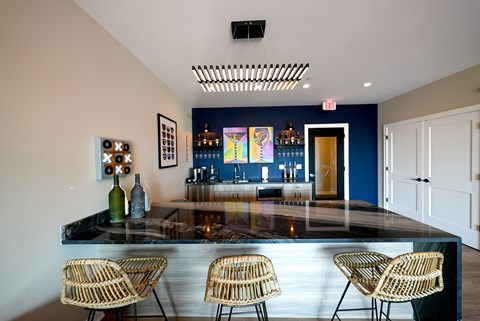 a bar with chairs and a blue wall in a room with a glass counter top