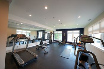 A spacious gym with treadmills, exercise bikes, and other equipment.