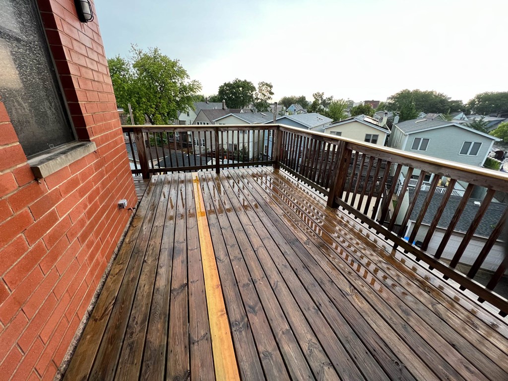 a balcony with a wooden railing and a brick building  at Elston 3434, Chicago, Illinois