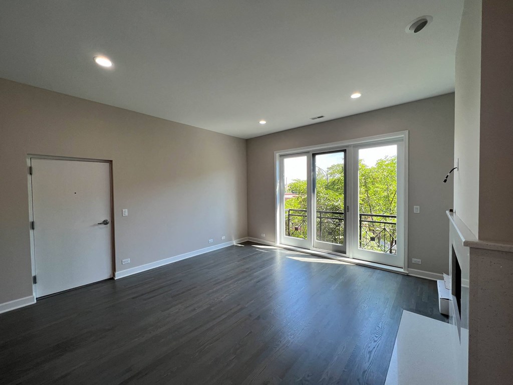 a living room with wood floors and a door to a balcony  at Elston 3434, Chicago, IL