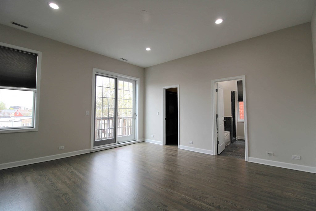 the living room of a new home with white walls and wood floors  at Elston 3434, Chicago, IL