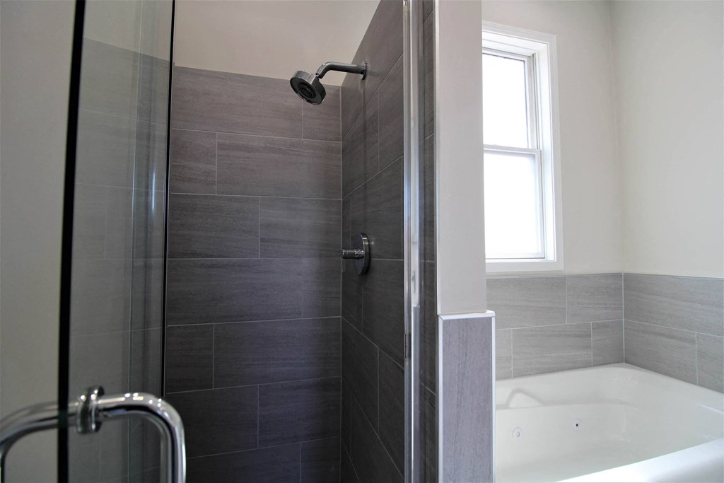 a bathroom with a shower and a tub and a window  at Elston 3434, Chicago, IL