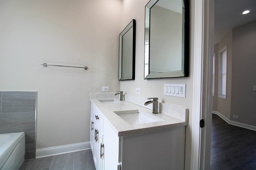 a white bathroom with a sink and two mirrors  at Elston 3434, Illinois