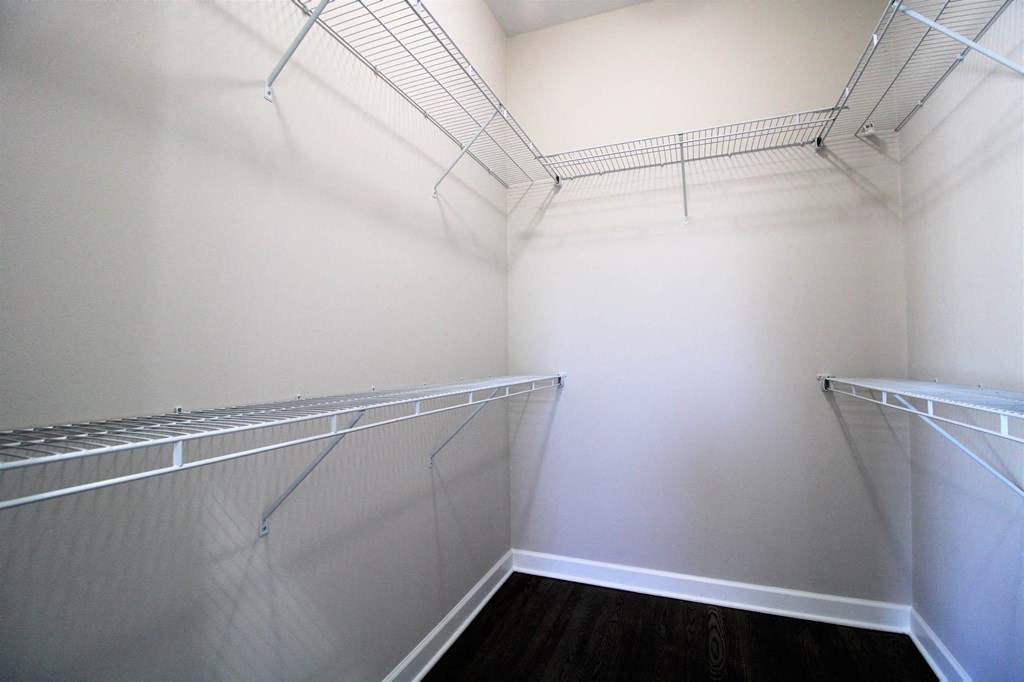 a walk in closet with white walls and shelves and mirrored closet doors  at Elston 3434, Illinois