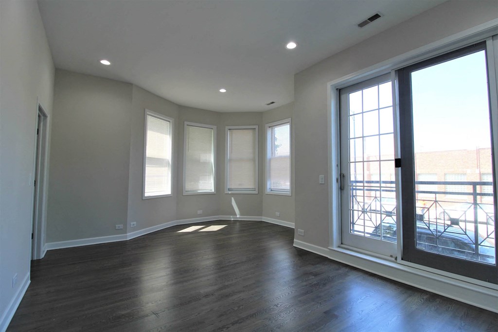 a living room with a large window and wood floors  at Elston 3434, Chicago, IL, 60618