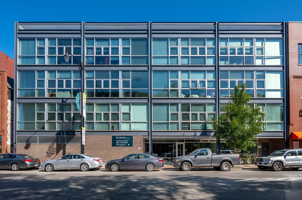 A modern building with a parking lot in front of it.